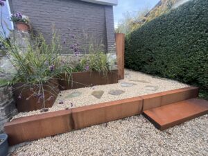 Aménagement en acier corten, bordure, couvre marche, bac à fleurs et range buches